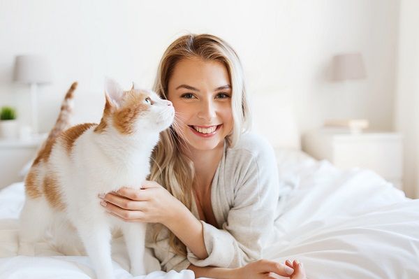 woman with cat lying in bed